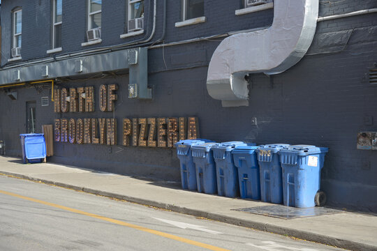 outdoor service area North of Brooklyn Pizzeria sign on the side of a building facing Palmerston Avenue (pizza shop located at 650 Queen St W) in Toronto