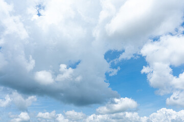 Fluffy white clouds drift across a clear blue sky, painting a breathtaking cloudscape