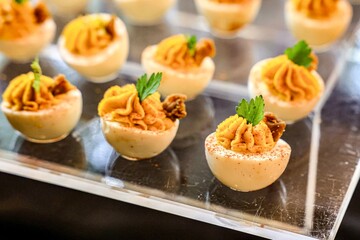 Gourmet Deviled Eggs Garnished with Herbs. A close-up view of gourmet deviled eggs elegantly garnished with fresh herbs and crispy toppings.