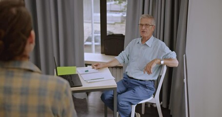 A dedicated mature student listens attentively during an engaging university lecture, diligently taking notes to deepen their understanding and retention of the academic material.