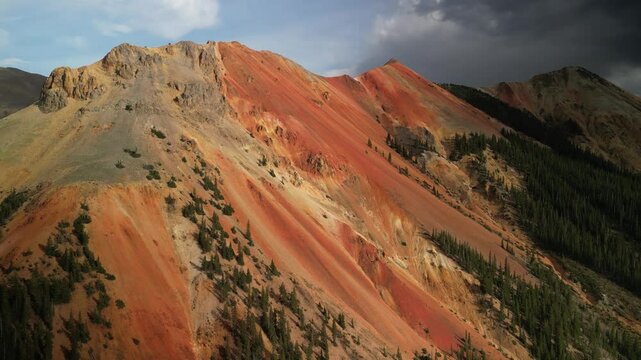 Aerial back away from Red Mountain near Ouray on Million dollar highway at sunset