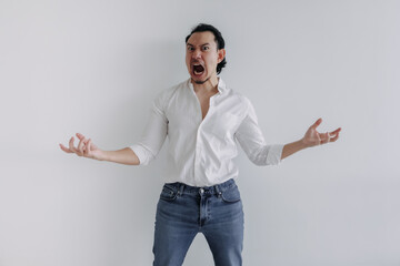 Angry face of long hair Asian man bun in white shirt and jean stand on white.