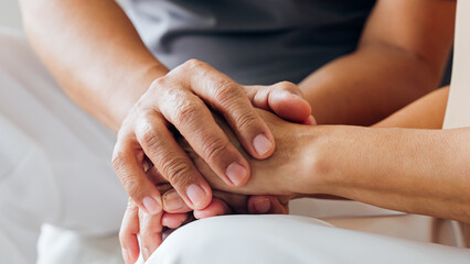 Close up view of caring elderly grandma wife holding hand supporting senior grandpa husband give...