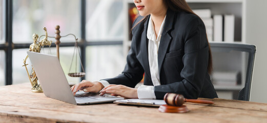 Focused Legal Professional: A female lawyer diligently works on her laptop in a professional...