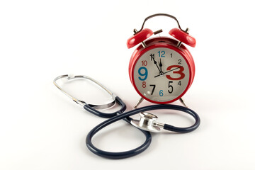 Stethoscope and red classic alarm clock