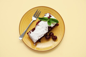 Plate with piece of tasty cherry strudel on yellow background