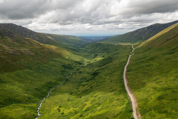 Panoramic view of river and dirt road in mountain valley near Hatcher Pass, Alaska landscape wilderness