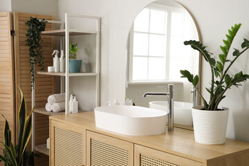Fototapeta premium Interior of light bathroom with sink, chest of drawers and mirror