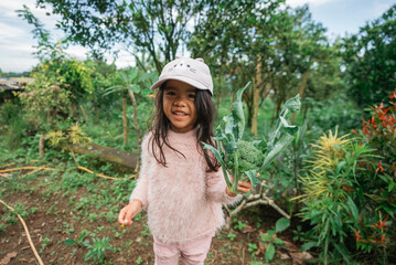 A joyful girl is happily enjoying her time in a vibrant garden, surrounded by nature