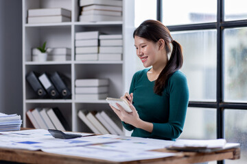 Business financing accounting banking concept. Business asian woman hand doing finances and calculate on desk about cost at home office. Woman work on desk with using calculator, finance accounting.