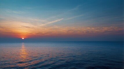 Obraz premium A breathtaking view of mountain ranges at sunset, with layers of blue hues and a warm orange sky. Silhouettes of mountains against a vibrant sunset sky