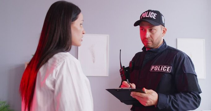 Police officer or detective investigates a crime by taking a statement from a woman who is a victim of burglary or theft at home. Gathering important information and supporting the victim.