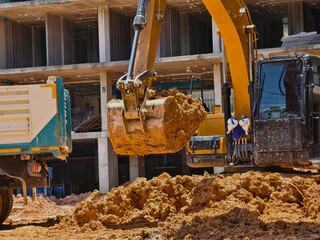 Excavator loads ground into a dump truck at a construction site