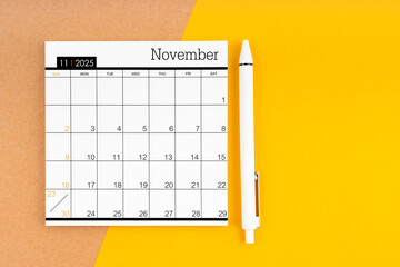 November 2025 Monthly calendar for 2025 year with pen on yellow.