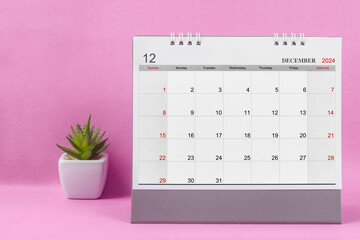 December 2024 desk calendar for 2024 on pink background.