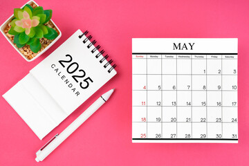 White calendar for May 2025 and pen on pink background, planning concept.