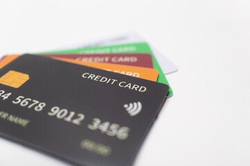 Black, green, orange, and maroon credit cards stacked together, symbolizing cashless transactions, digital finance, and modern banking solutions.