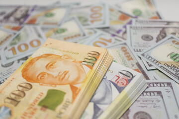 OrangeSingapore dollar bills stacked on US dollars, symbolizing currency exchange and financial transactions Ideal for business and finance visuals.