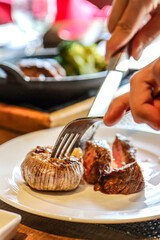 Cutting into a roasted garlic and steak dish