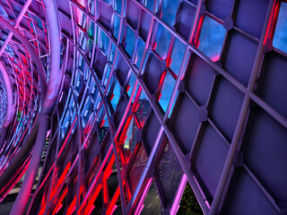A stunning tunnel with vibrant purple and blue ceiling lights