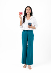 Beautiful Asian woman holding credit card and using smartphone on white background.