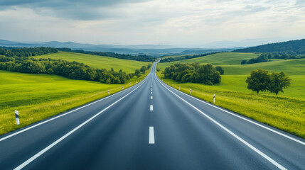 Fototapeta premium A winding highway through lush green hills under overcast skies