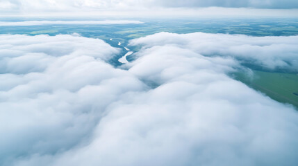 Obraz premium Flying above thick clouds revealing green fields and winding rivers below