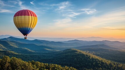 Fototapeta premium A balloon drifting in a clear blue sky, with scenic mountains and forests stretching below.