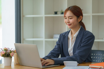 Fototapeta premium Asian businesswoman working with a laptop at the office.