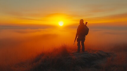 A lone hunter stands on a mountain top, silhouetted against a fiery sunrise. He holds a rifle and wears a backpack, looking out over a vast expanse of clouds.
