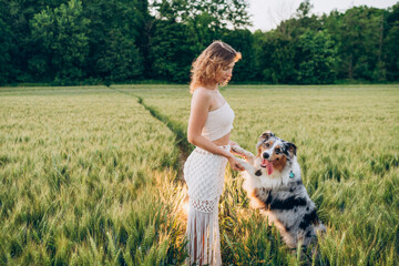 vibrant green rye field, capturing the bond between humans and pets