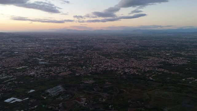 A breathtaking aerial view of Ercolano,with the city nestled between the sea and the mountains.Drone captures the stunning coastal panorama,showcasing the ancient ruins and the shimmering waters below