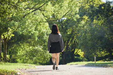 Fototapeta premium 夏の公園で散歩している女子高校生の姿