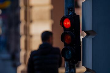 Red traffic light with persons in the background in Riga signaling no pedestrian walking allowed at...