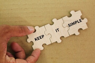wooden puzzle with the words keep it simple. the concept of facilitating or easy