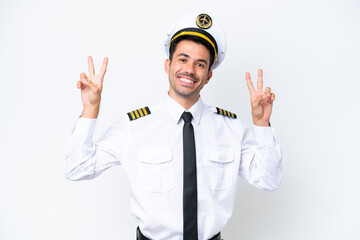 Airplane pilot over isolated white background showing victory sign with both hands © luismolinero