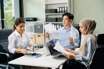  Asian businesspeople while collaborating on a new project.  using a laptop and tablet