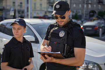 Patrol police team working on city street with parked cars