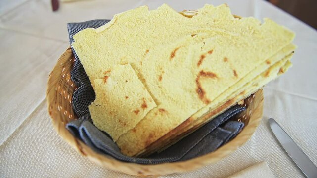 Pane carasau Sardinian music bread, homemade food in kitchen basket on table in Sardinia, Italy fresh baked flatbread macro closeup