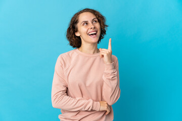 Young English woman isolated on blue background pointing up a great idea