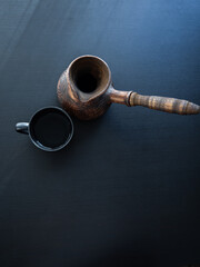 A COFFEE POT AND A CUP ARE ON THE BLACK TABLE