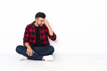 Young handsome man sitting on the floor laughing