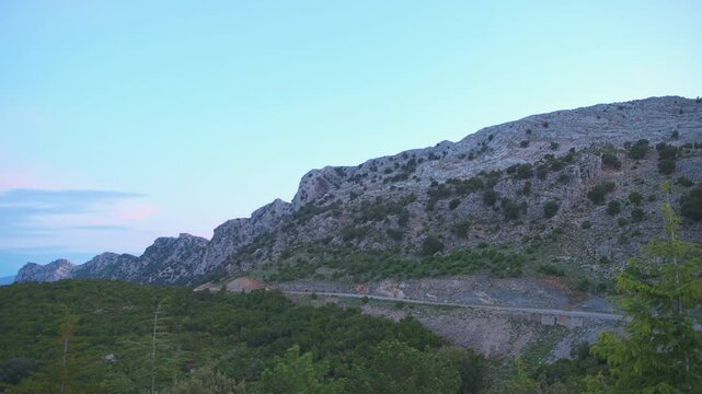 Gorropu canyon at sunrise with view on mountain road in village in Sardinia island, Italy with colorful clouds sky dramatic landscape