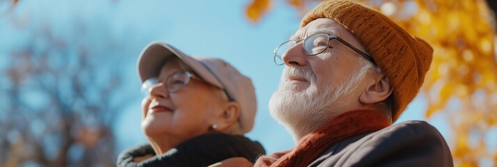 An elderly couple, wearing hats and scarves, enjoys the autumn sunshine outside, symbolizing warmth, comfort, and the beauty of aging gracefully together.