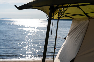 View of the tent against the sunlight-reflected sea