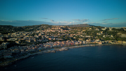 Fototapeta premium A stunning aerial shot of Pozzuoli, highlighting its scenic coastline and vibrant harbor.The drone captures the ancient Roman ruins, the calm sea, and the natural beauty surrounding the historic city.