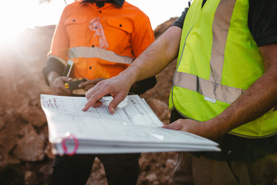 Builders looking at the blueprints at the construction site