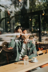 Couple enjoying a warm afternoon together in a cozy cafe, sharing smiles and laughter over coffee while seated by a large window