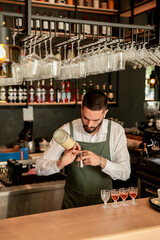Skilled bartender artfully pouring colorful cocktails in a lively bar setting during the evening rush