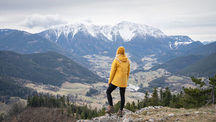 Female hiker on the top of the mountain enjoying the view on snowy peak in background, Austrian Alps